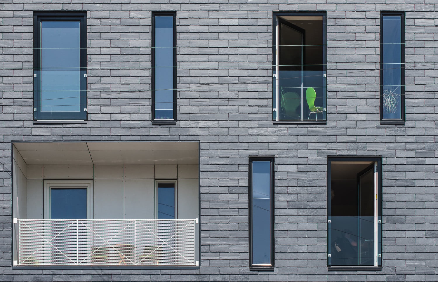 Durch die verspringende Anordnung der Freibereiche und Fenster in wechselnder Breite entsteht ein lebendiges Fassadenbild.
