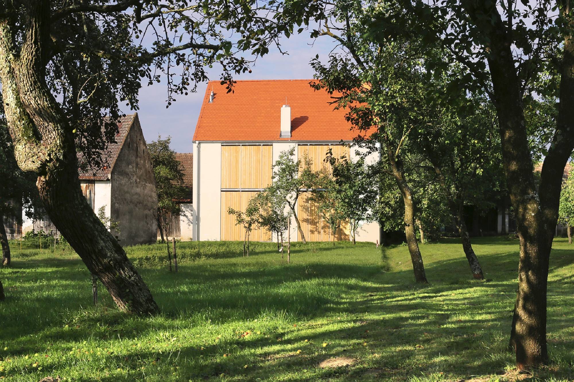Der Neubau wurde auf der straßenabgewandten Seite zugefügt und folgt in Ausrichtung und Abstandsfläche der Reihung des Gehöfts.