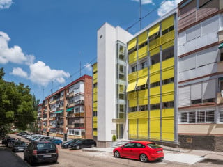 Ein sonniges Gelb prägt die Fassade des Hauses Nr. 50 in der Calle de San Pedro de Cardeña im Norden Madrids nach der Sanierung.