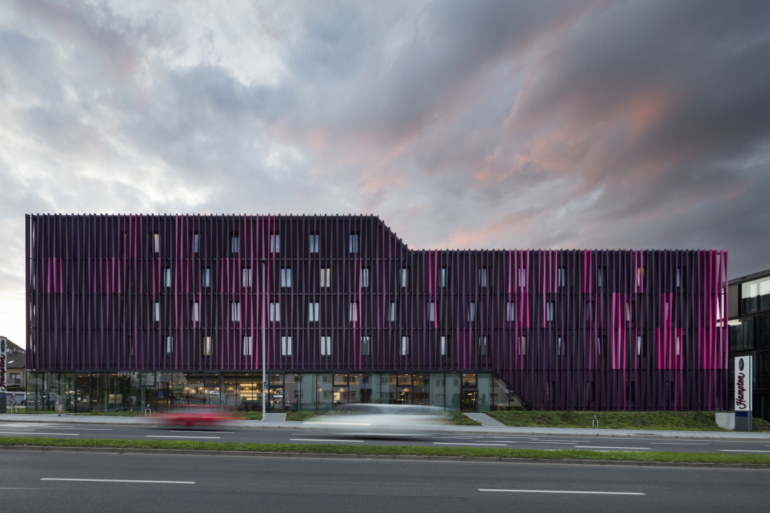 Die Fassade zeigt Variationen von Purpur und entwickelt je nach Blickrichtung und Lichteinfall eigene Dynamik.