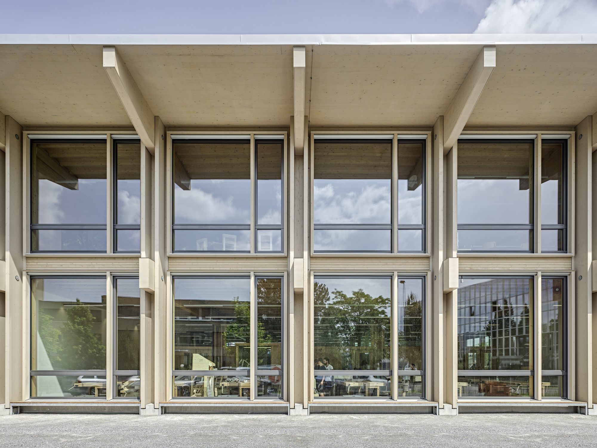 Der lichtdurchflutete Bau bietet auf zwei Geschossen ausreichend Platz für Werkstatthalle, Maschinen- und Unterrichtsräume für angehende Zimmerer und Holzbearbeiter.