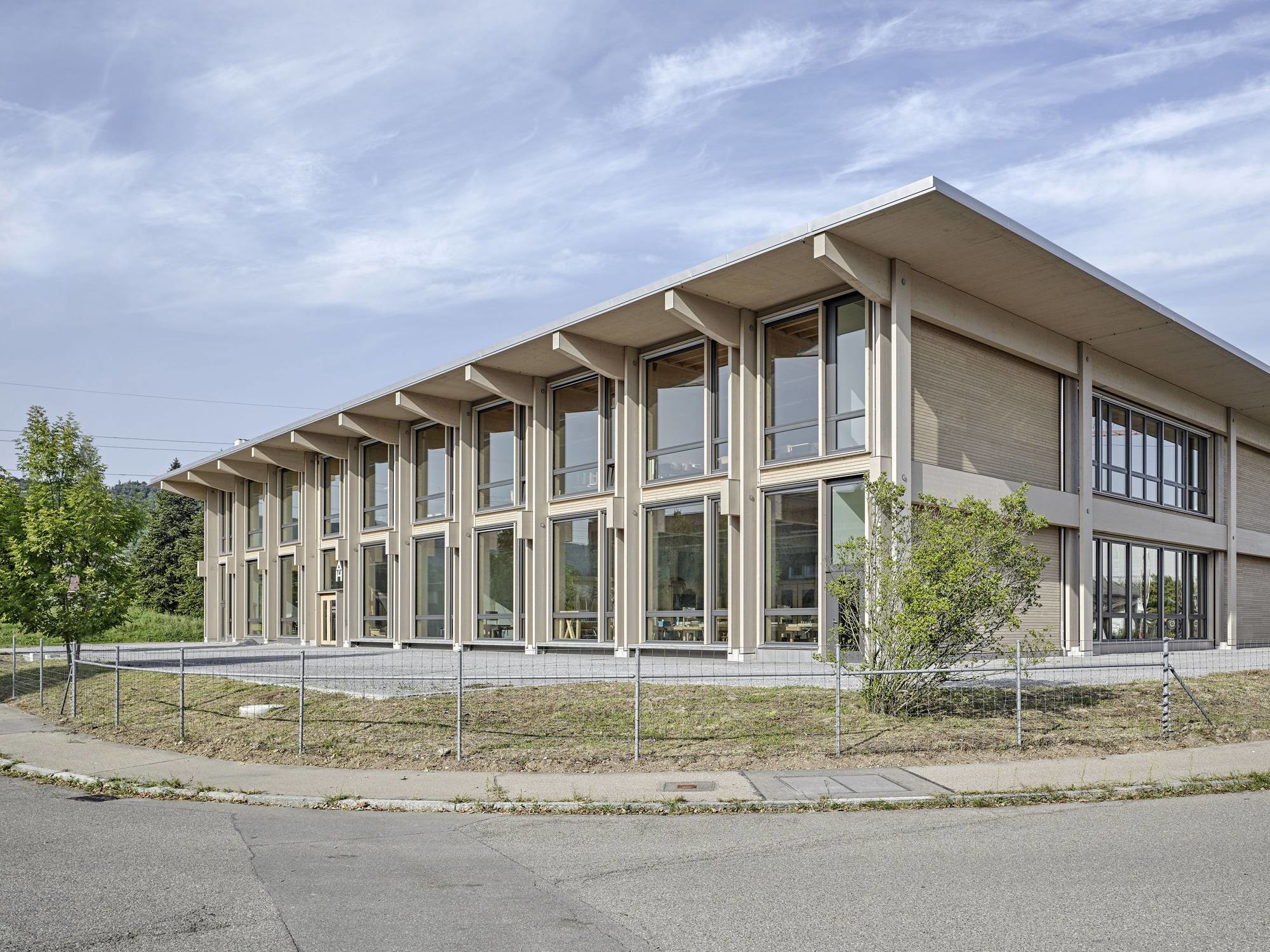 Das äußere Erscheinungsbild ist maßgeblich durch die filigrane außenliegende Tragstruktur mit weit auskragendem Dach sowie von den Materialien Holz und Glas bestimmt.