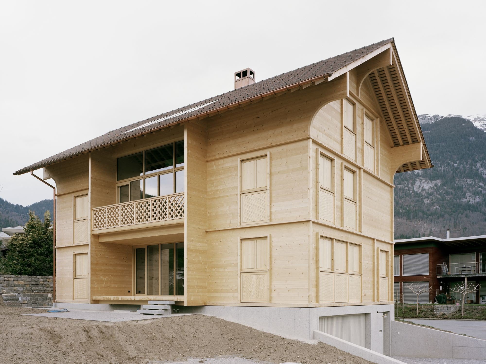 Die ausschließliche Verwendung von Holz über dem Betonsockel bestimmt den architektonischen Ausdruck. Gestalterisch wird eine traditionelle regionale Bauform mit Satteldach aufgegriffen, aber neu interpretiert.