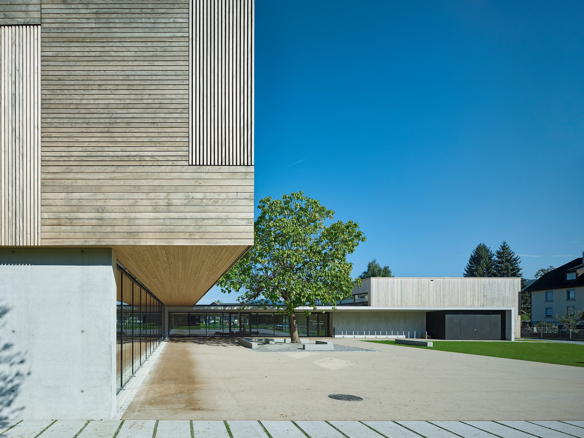 Das Hauptgebäude ist ein 70 Meter langer Klassentrakt, der über eine verglaste Aula mit der sanierten Turnhalle verbunden ist.