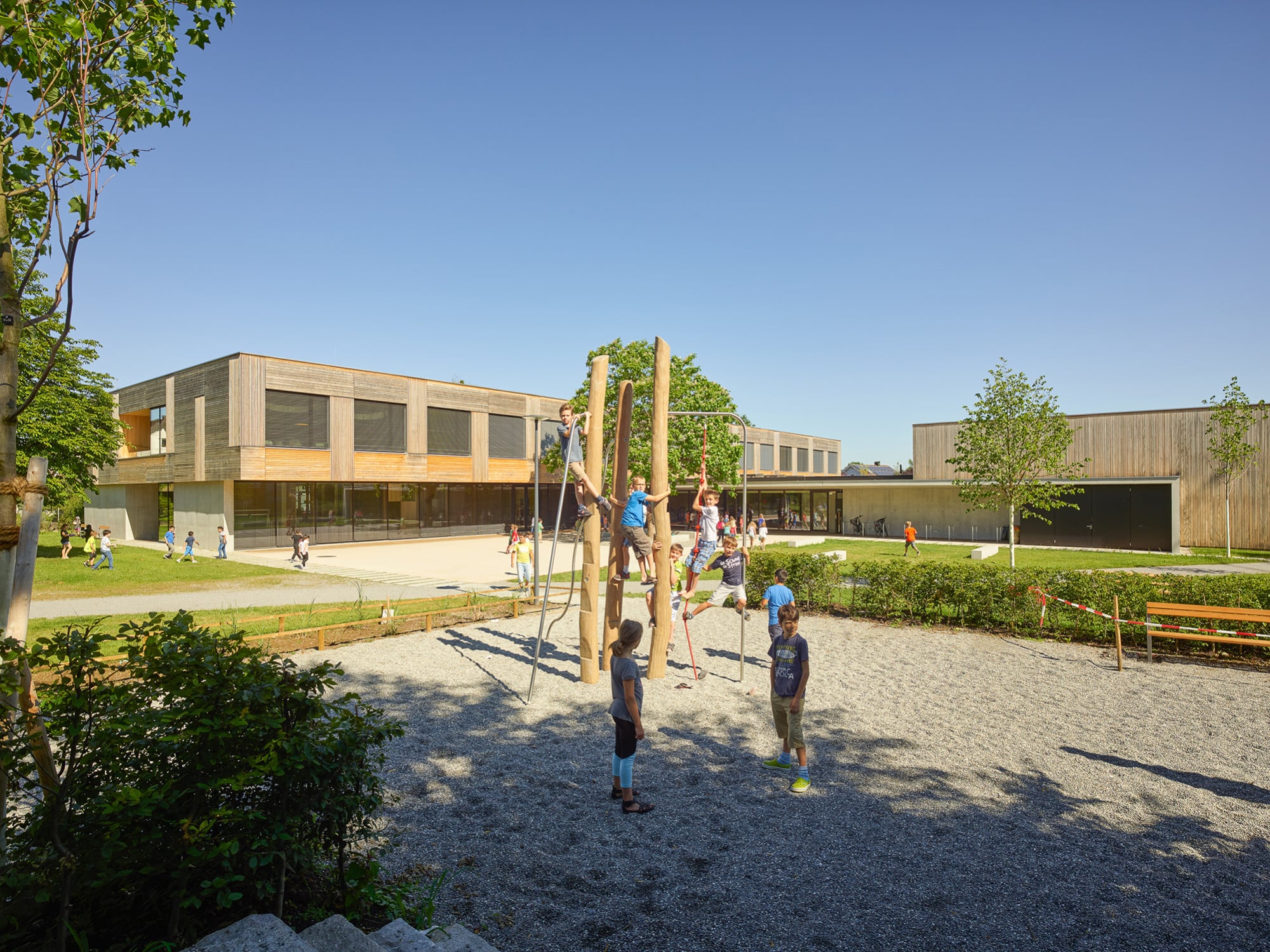 Die Stahlbetonkonstruktion des Neubaus wird im Obergeschoss durch Holzbauweise ergänzt. Die Fassaden sind mit Latten aus Weißtanne bekleidet.