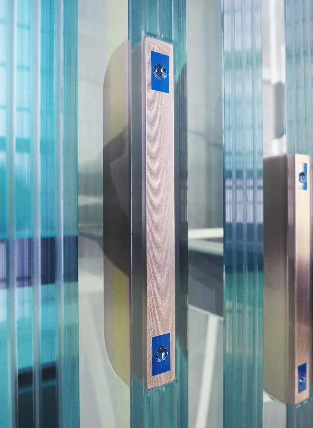 In die Glasschwerter einlaminiert wurden jeweils fünf Titan-Fittings, über welche die statische Kopplung zwischen Fassadenverglasung und Glasschwert gewährleistet wird.