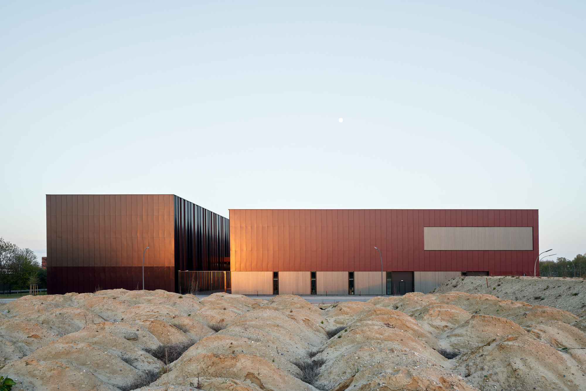 Die Planer vom Büro DFZ Architekten wählten für die Hülle ein Metalloptik beschichtetes Aluminiumblech in rotbraun und bronze. Um die Innenräume mit ausreichend Tageslicht zu versorgen, wurden gefüllte Profilglaselemente eingesetzt.