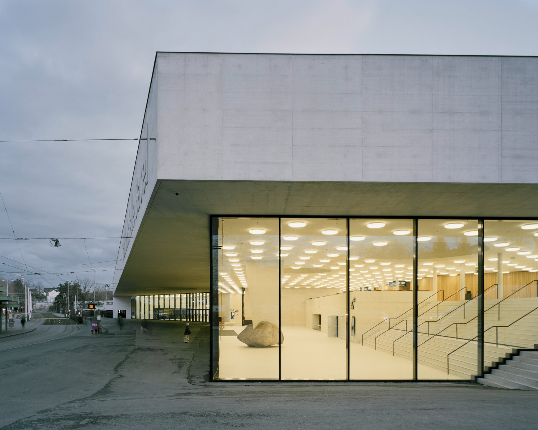 Durch die zurückhaltende, gläserne Fassade aus überlangen Scheiben, entsteht ein fließender Übergang zwischen Außen- und Innenraum.