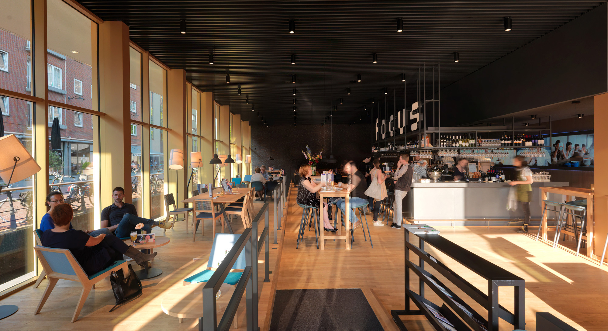 Ein Café liegt im Erdgeschoss hinter der gläsernen Fassade. 