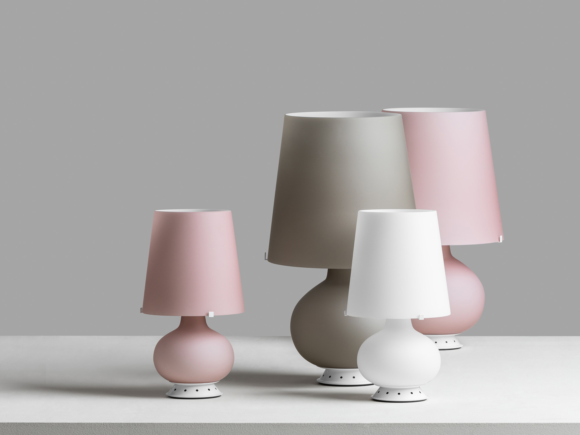 Die Leuchte besteht aus gefrosteten, mundgeblasenen Glas, wobei Fuß und Schirm in derselben Farbe gehalten sind. 