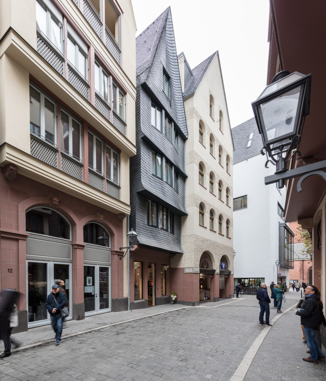 Auf dem Sockelgeschoss aus rotem Mainsandstein thront die in vier Stufen gestaffelte, bewegte Fassade.