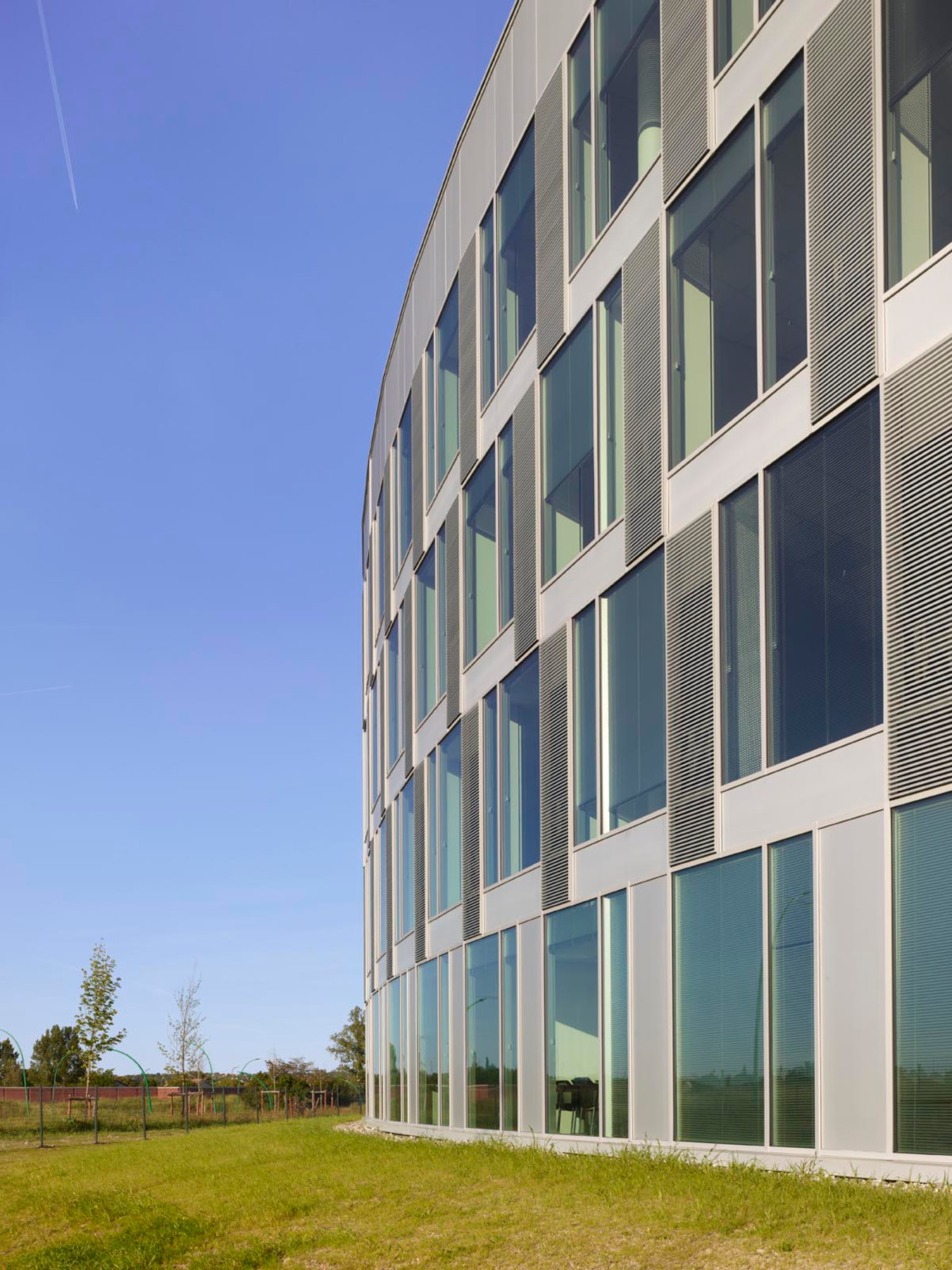 Die Nordfassade, die der Straße zugewandt ist, weist eine vertikale Struktur aus Betonfertigteilen, Fensterflächen und den Lüftungsgittern der integrierten Klimaanlagen auf.