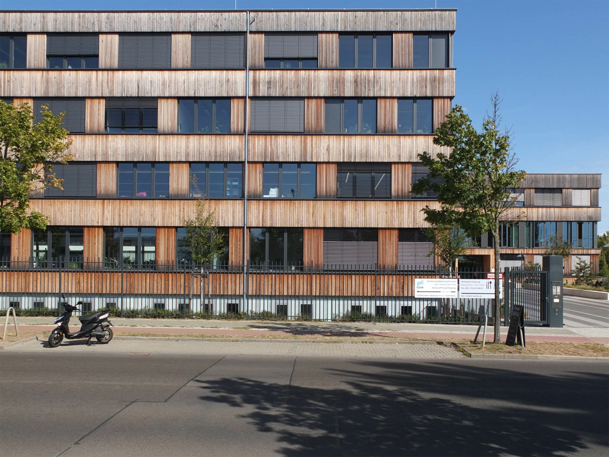 Firmensitz Flexim in Berlin-Marzahn, geplant von ZRS Architekten Ingenieure (2017): Das Untergeschoss des Skelettbaus, Stützen und Unterzüge sowie die aussteifenden Erschließungskerne sind bis ins 2. OG in Stahlbeton ausgeführt. Die Geschossdecken sind Holz-Beton-Verbundelemente. Das 3. OG ist bis auf die Erschließungskerne eine reine Holzkonstruktion. Eine vorgehängte Holzrahmenfassade bildet den äußeren Gebäudeabschluss.