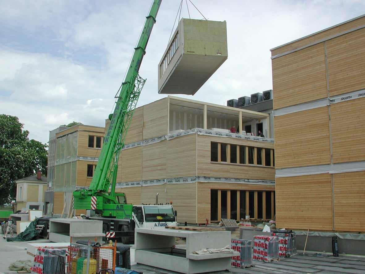Der hohe Grad der Vorfertigung sorgt für extrem kurze Bauzeiten und eine hohe Ausführungsqualität (im Bild: Transport der Raumzellen mit dem Kran während der Bauarbeiten am Impulszentrum Reininghausgründe)