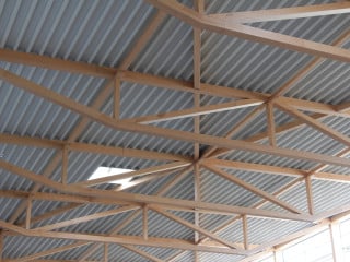 SWG Produktion Schraubenwerk Gaisbach. 2019: Tertiärtragwerk: Pfetten im Abstand der Knotenverbindungen des Sekundärtragwerks; Sekundärtragwerk: einfeldriges Strebenfachwerk mit Pfosten, innere Streben druckbeansprucht, äußere Streben zugbeansprucht; Primärtragwerk: 82 m langes und 3,8 m hohes, zweifeldriges Pfostenfachwerk mit Druckdiagonalen und Zugpfosten. Einzelspannweiten: 42 m (L) und 40 m; statische Höhe (H) entspricht dem Abstand der Schwerachsen von Obergurt und Untergurt H = 3,52 m – H / L = 1 / 12. Querkraftnulldurchgang liegt bei ca. 40% der Feldlänge vom Endauflager entfernt.