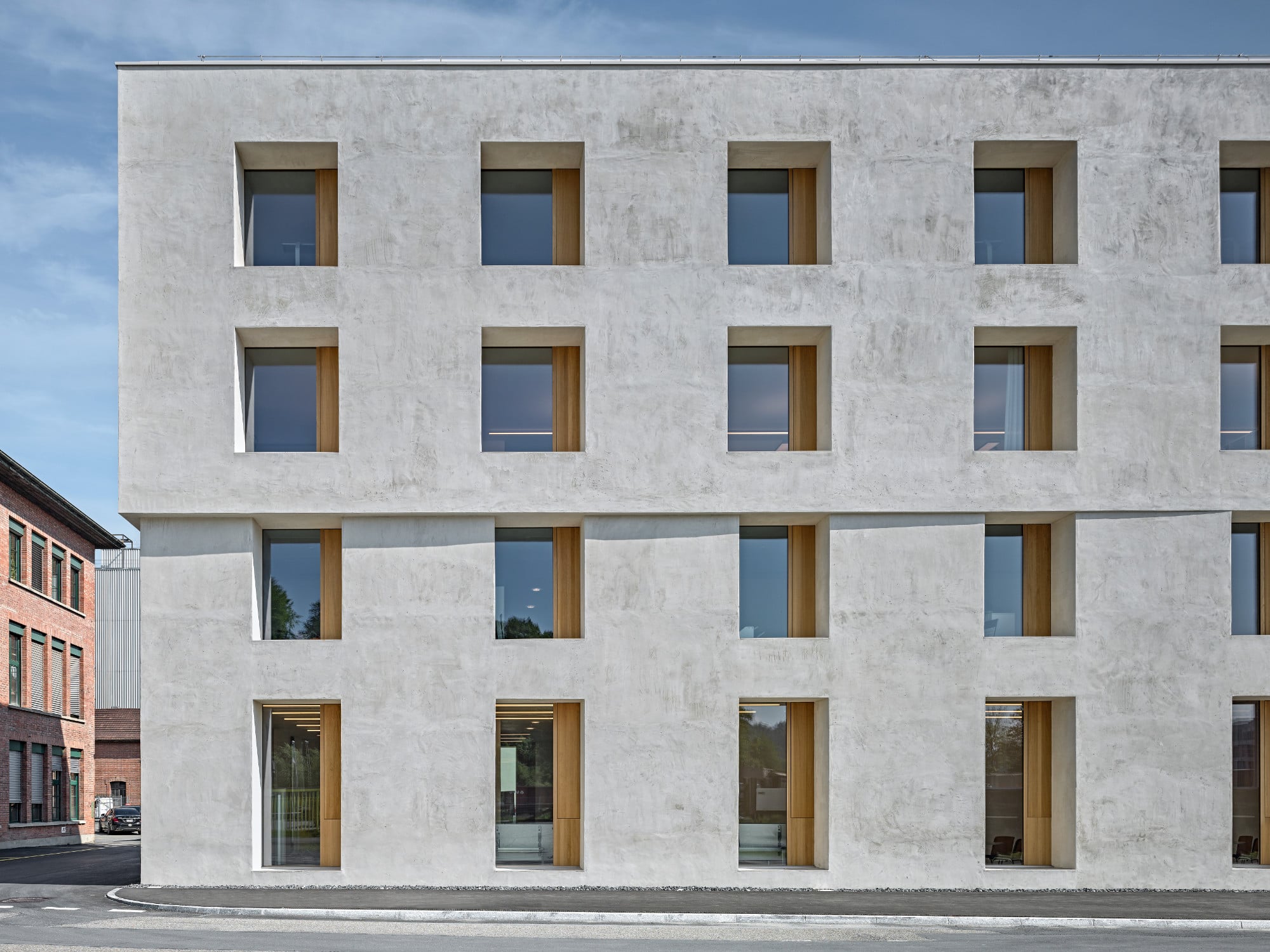 Die Lochfassade charakterisiert sich durch einen regelmäßigen Rhythmus aus innenliegenden Fenstern mit besonders tiefen Laibungen, wodurch der massive Charakter des Baus betont wird.