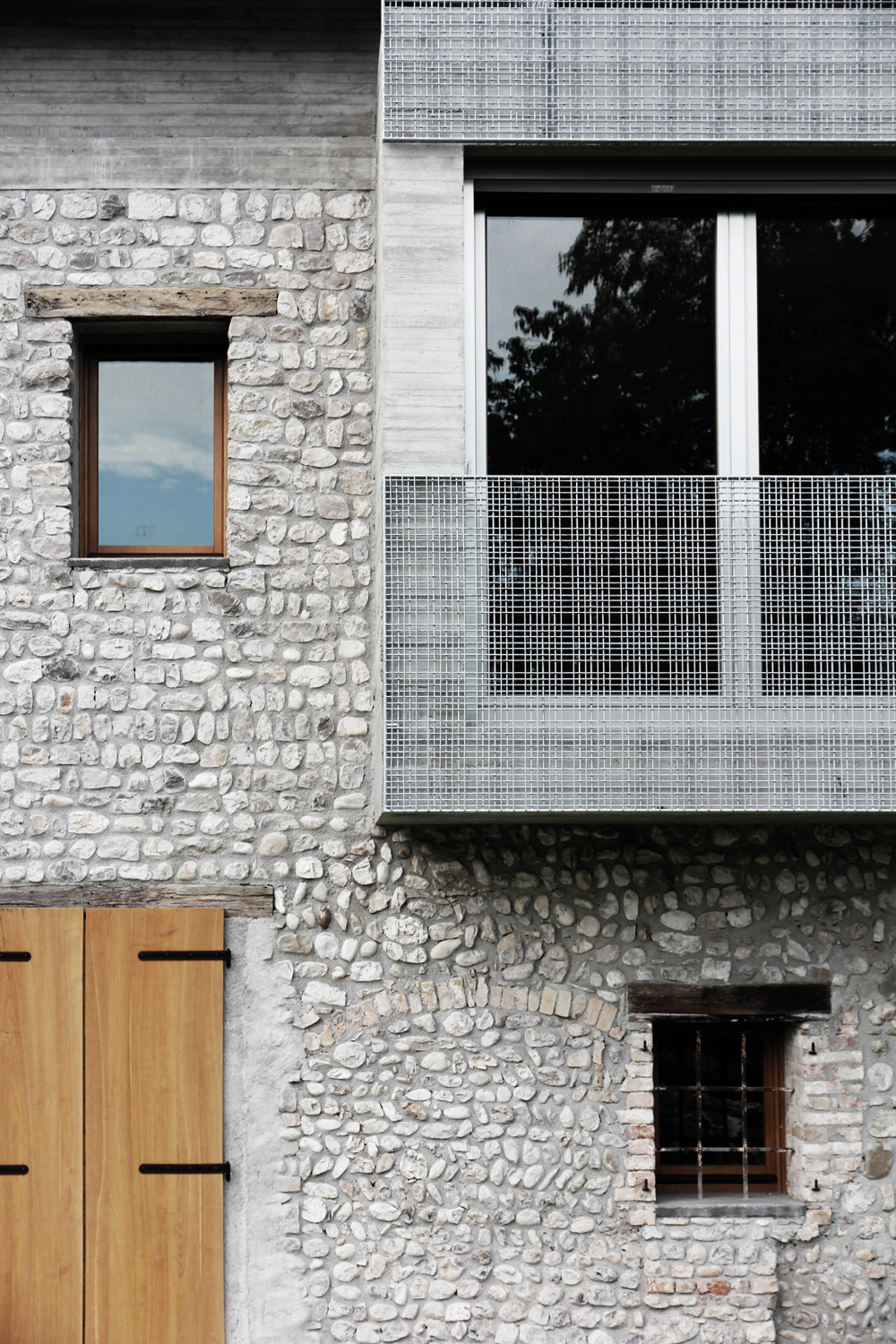 Neue Raumeinheiten aus Beton durchbrechen und überformen die Fassade.