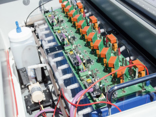 Der Demonstrator des Zink-Luft-Speichers soll dessen Aufbau verdeutlichen: Die blauen Kästen sind die Zellen, im Gefäß links befindet sich das Elektrolyt.