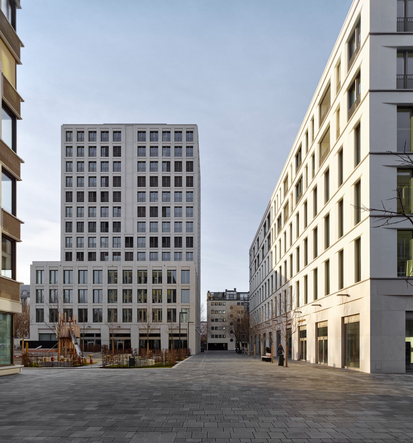 Nach Norden hin ist dem Neubau ein Freiraum vorgelagert, der als Spielplatz genutzt wird.