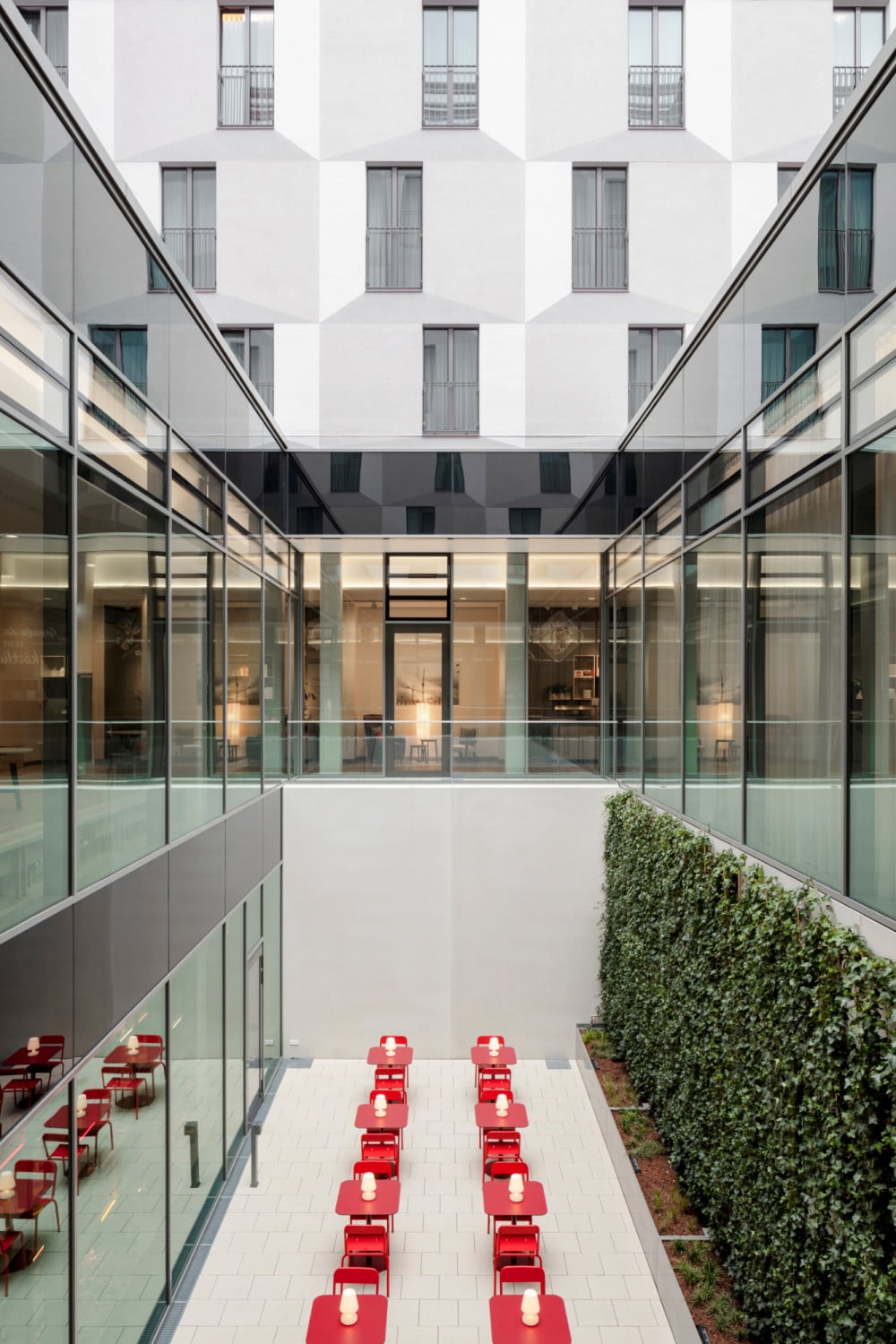 Gleich dahinter liegt das längliche Atrium, flankiert von einer grünen Fassade.