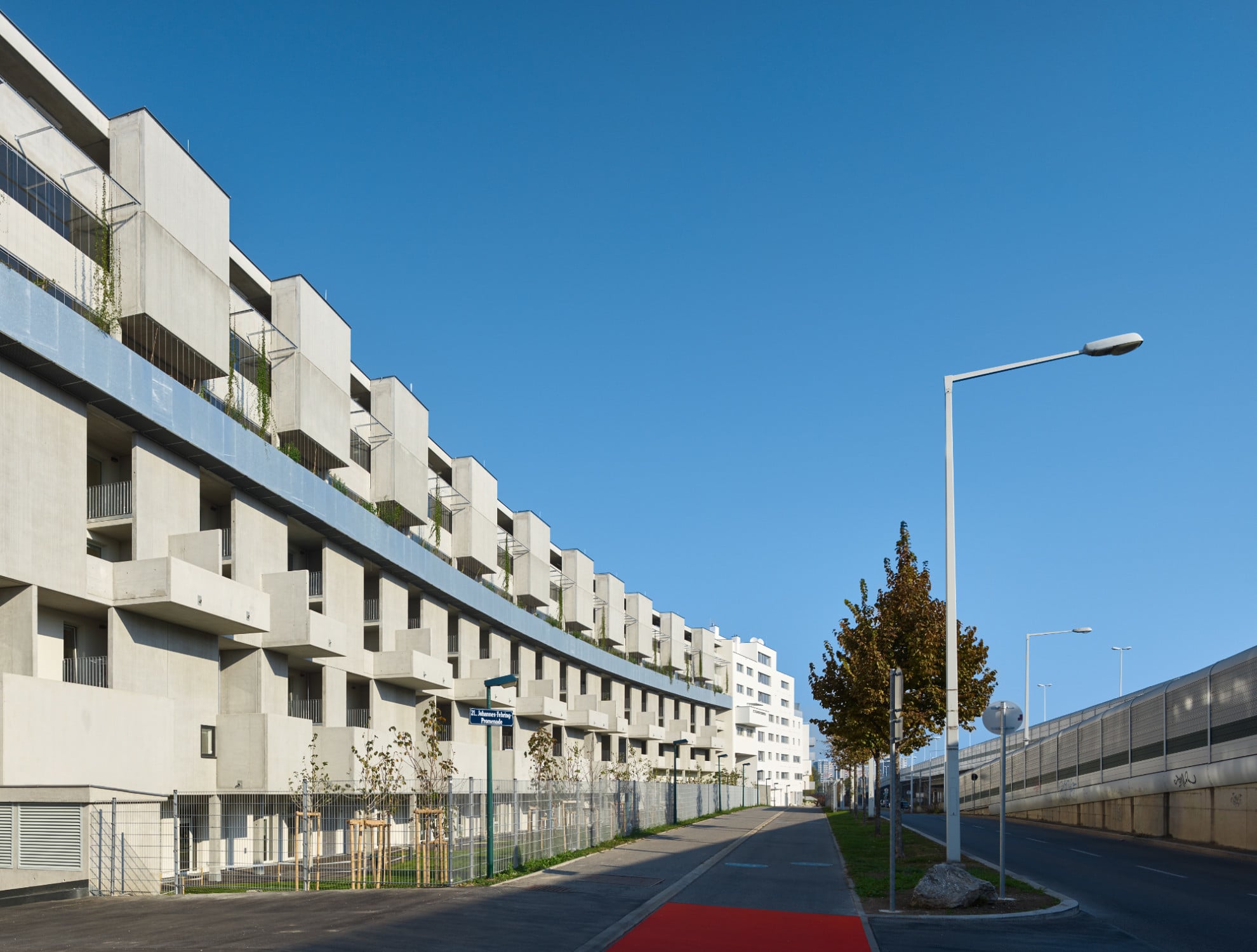 Eine gebogene Grundrissform und eine rhythmisch gegliederte Fassade prägen den langgezogenen Geschosswohnungsbau. 