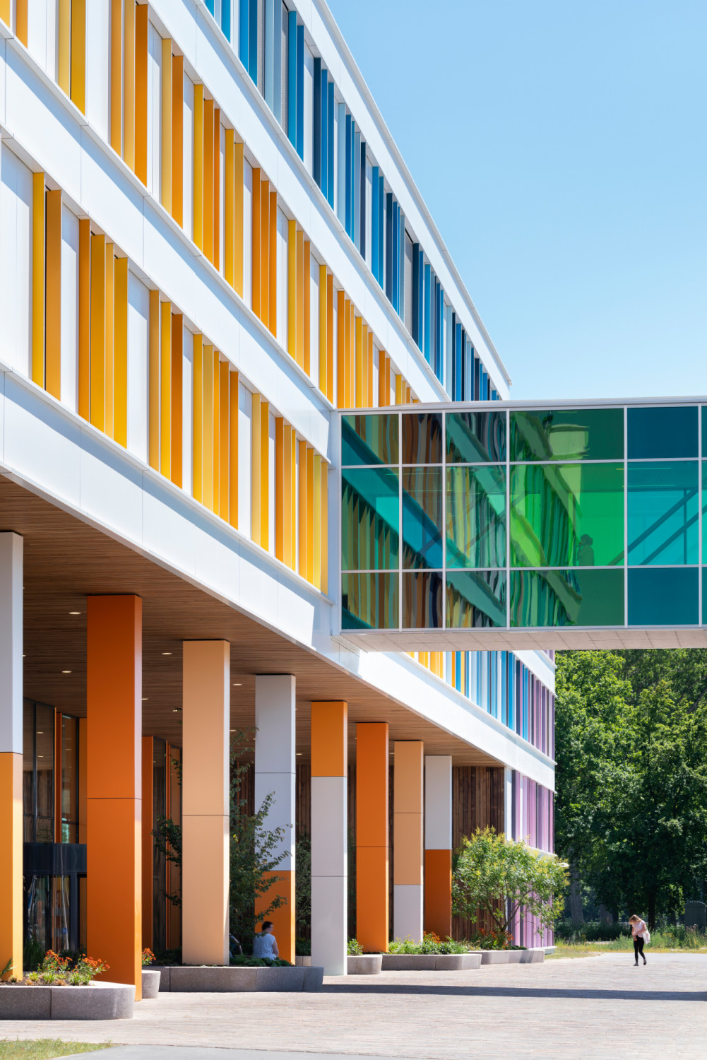 Die Fassade aus weißen Aluminiumpaneelen ist mit farbenfrohen Elementen durchsetzt.