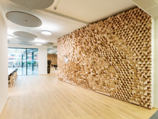 Für die neue Cafeteria im Erdgeschoss eines Geschäftshauses in Esslingen im Kanton Zürich setzten die Planenden vom Büro Basler und Hofmann auf speziell geplante Akustikwände aus Holz.