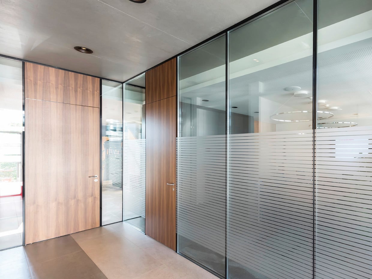 Mit Frameless bietet Hoba ein feuerhemmendes Türelement mit Holztürblatt an, das zargenlos und damit bündig in Verglasungen eingebaut werden kann. 