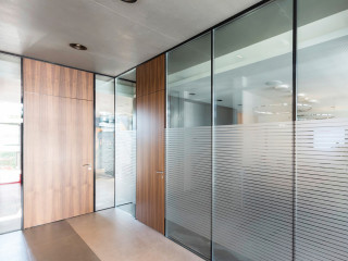 Mit Frameless bietet Hoba ein feuerhemmendes Türelement mit Holztürblatt an, das zargenlos und damit bündig in Verglasungen eingebaut werden kann. 