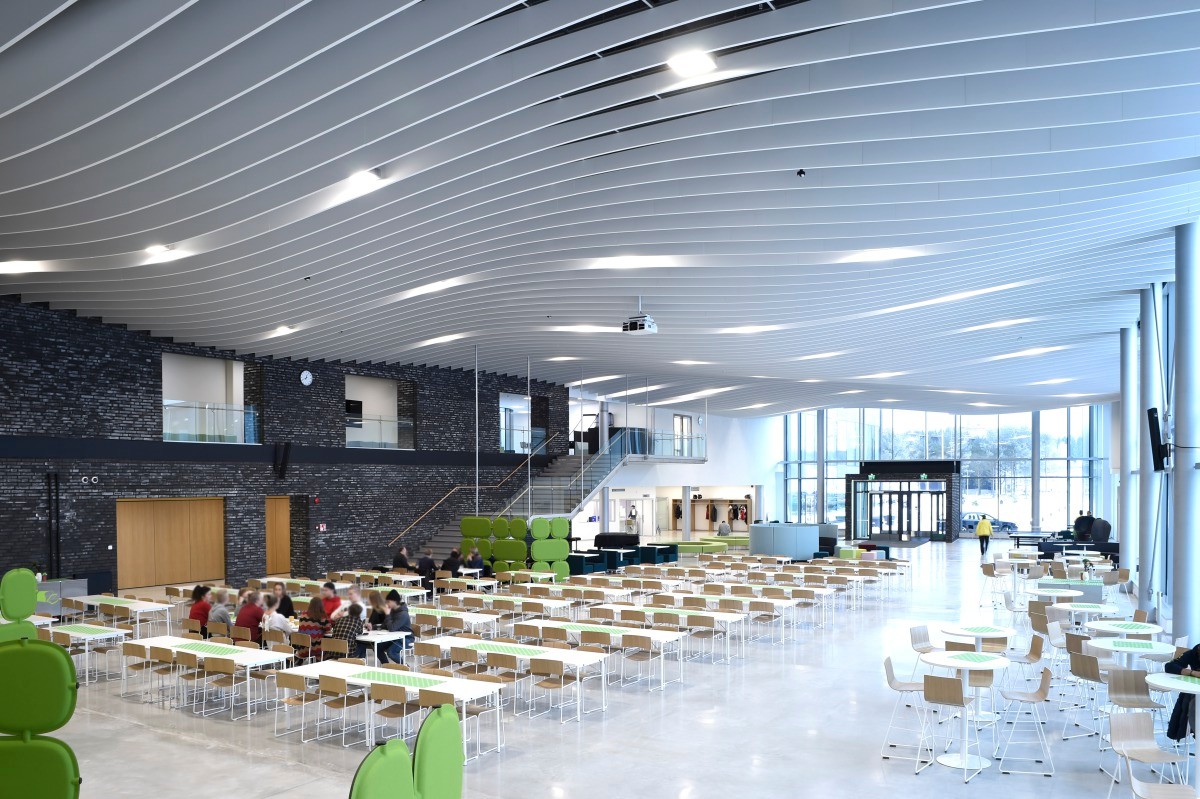 In der Eingangshalle des neuen Kurikka Campus in Finnland wellenförmige Elemente in Reihe gehängt.