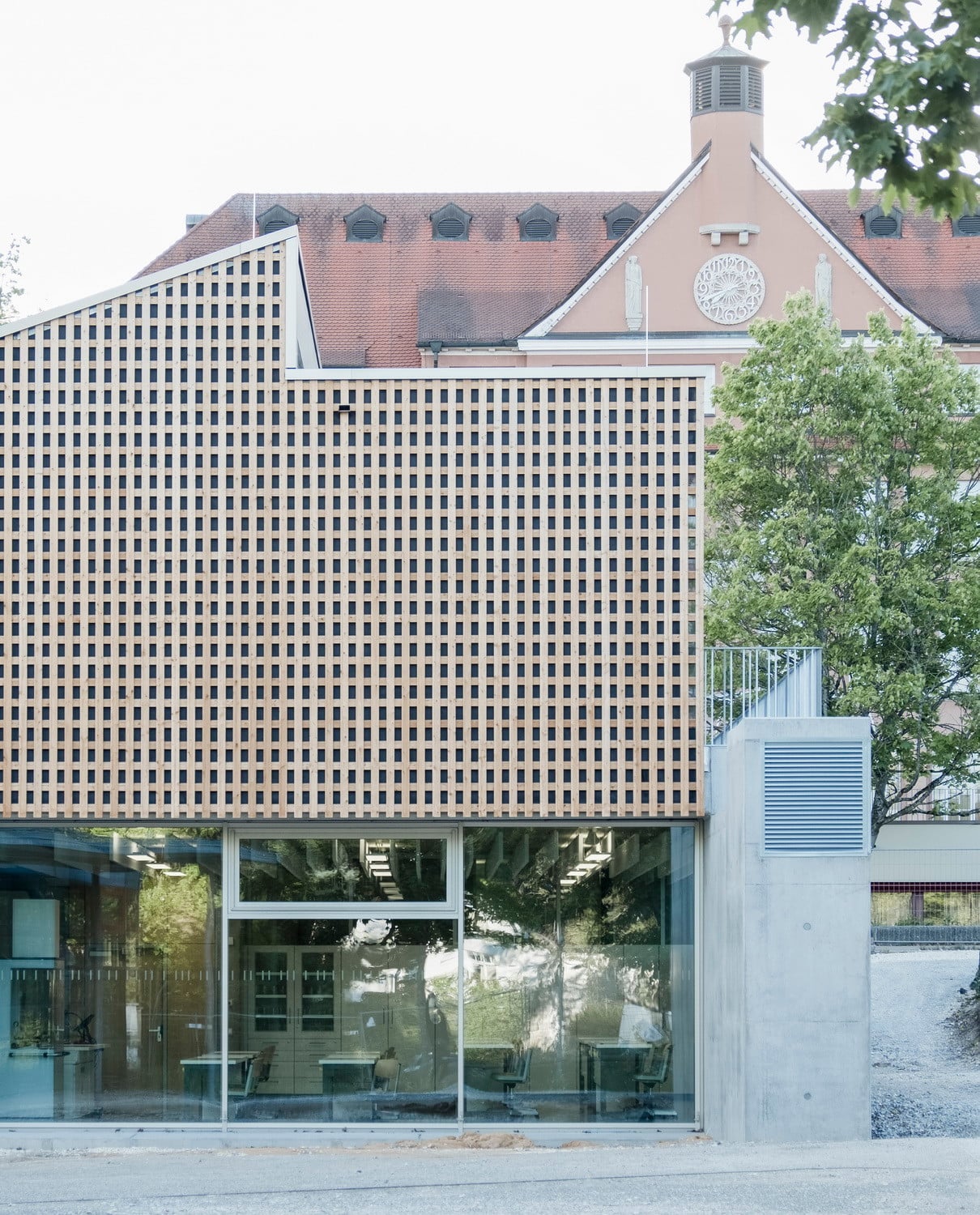 Aus Respekt vor dem traditionalistischen Bestandsbau gräbt sich das Erdgeschoss teilweise in den Boden ein und überwindet dabei gleichzeitig eine leichte Geländeneigung.