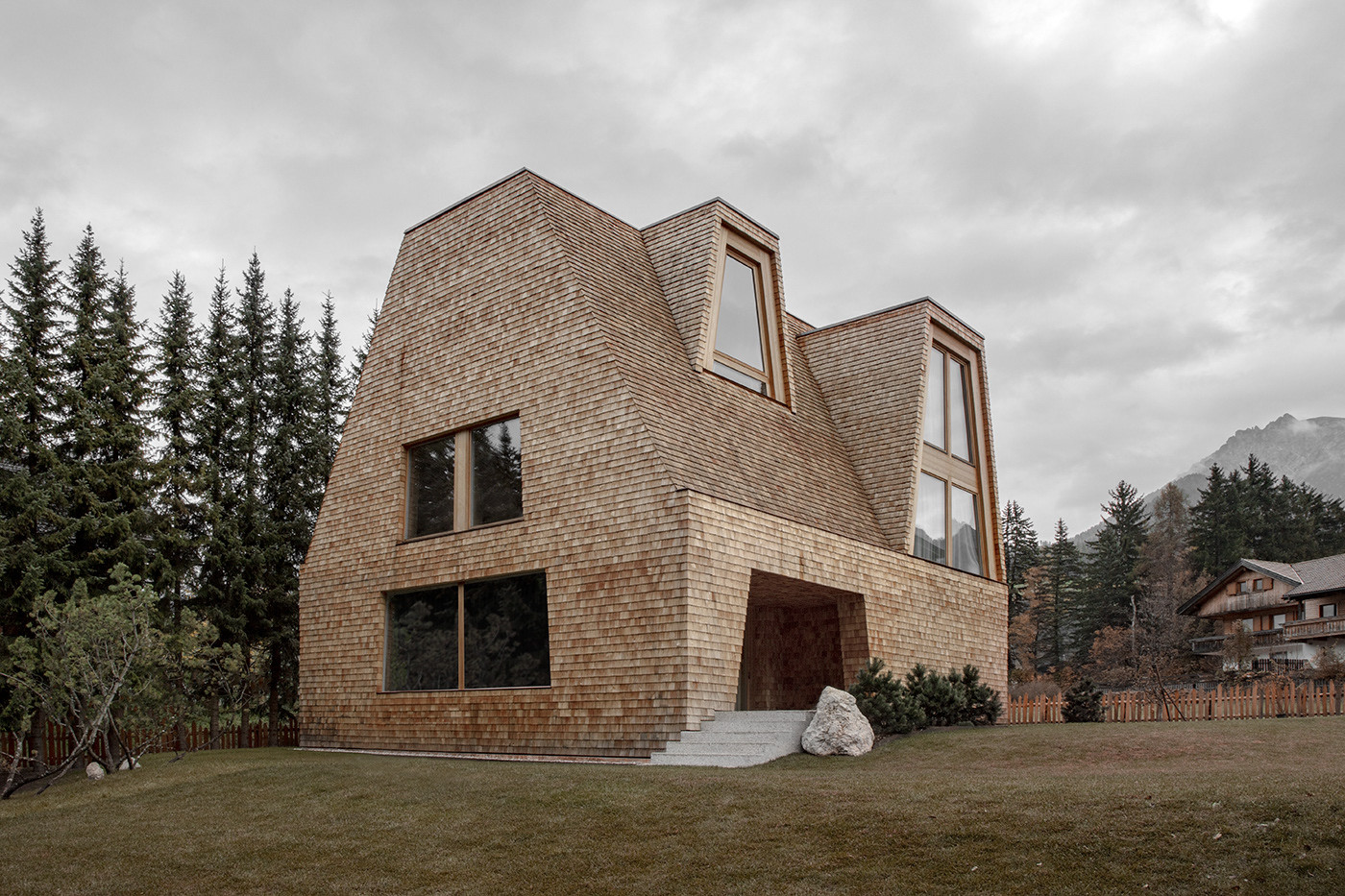Den in massiver Holzbauweise errichteten Bau mit bemerkenswertem Dach und markanten Fenstern entwarfen Pedevilla Architekten. 