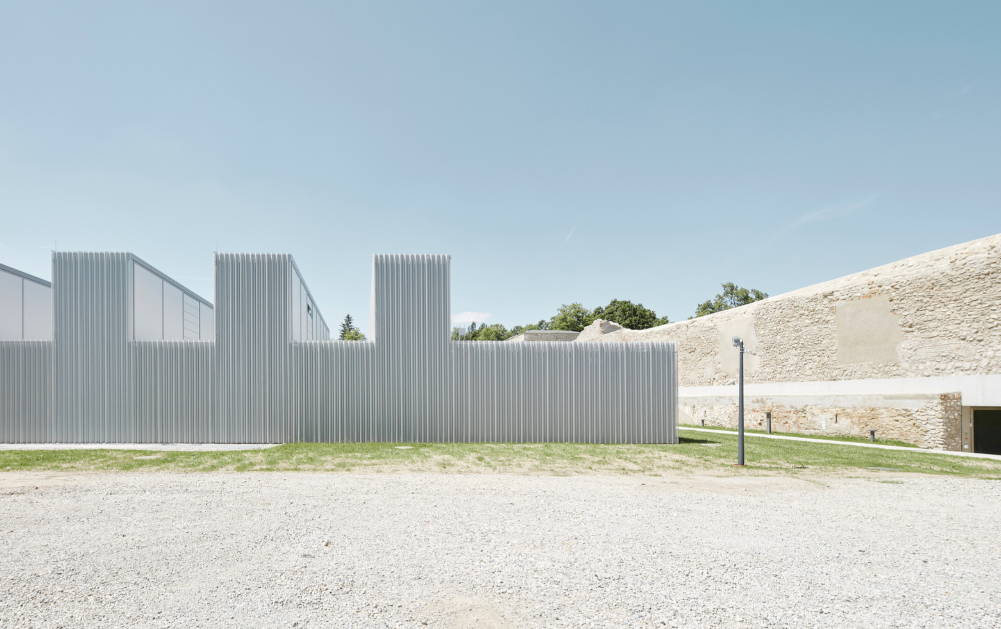 Die Fassade aus gewellten Aluminiumprofilen steht im Kontrast zum historischen Mauerwerk von Kasematten und Bastion.