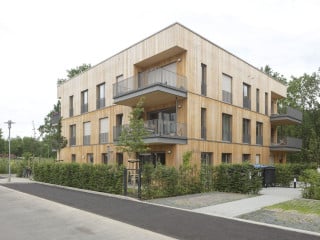 Holz prägt die Fassade und die Konstruktion des dreigeschossigen Mehrfamilienhauses.