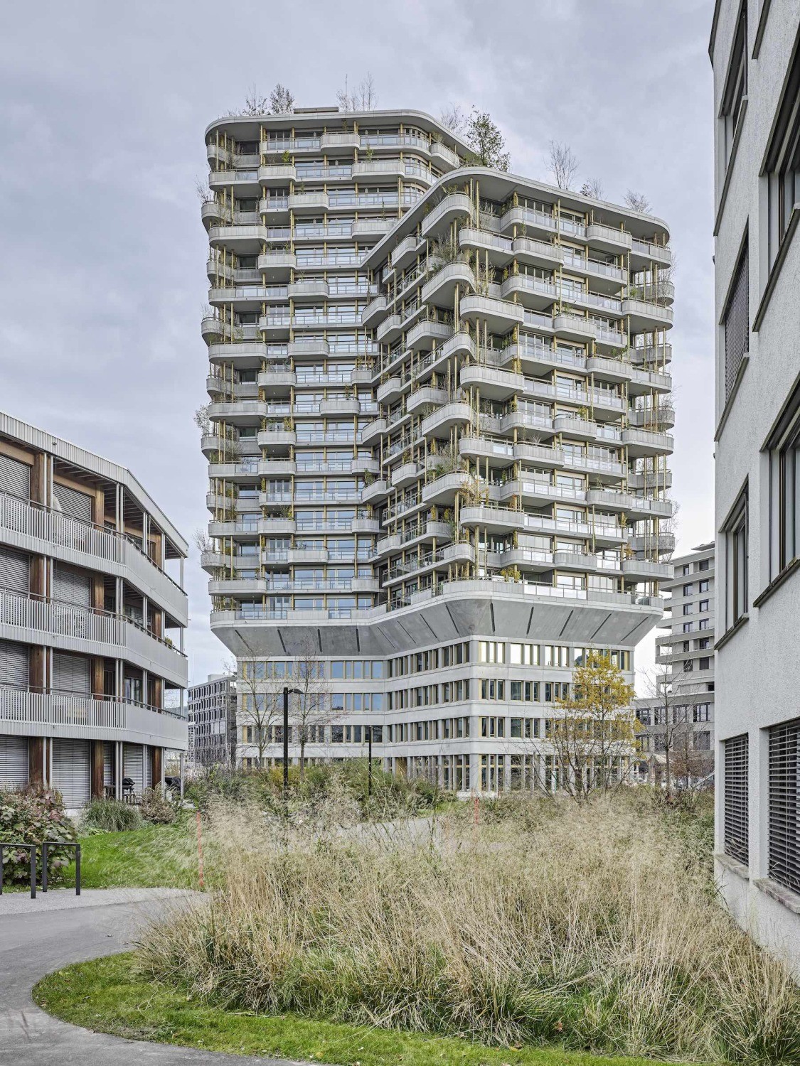 Während die Sockelfassade streng gegliedert und glatt daherkommt, zeigt die Gebäudehülle der Wohngeschosse mit ihren Balkonen, Terrassen und Wintergärten lebendige Tiefe.