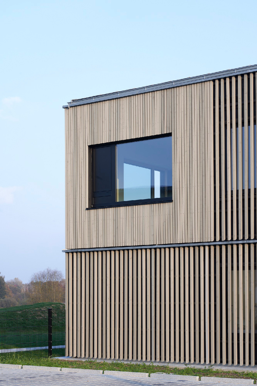 Hinter den Holzlatten in lockerer Reihung befinden sich die Fenster der Nebenfunktionen. 