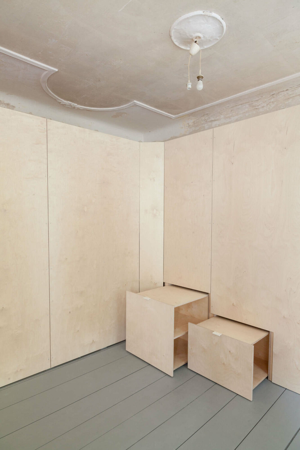 Das Planungskollektiv entwickelte für den großen, erkerbewehrten Wohnraum ein hölzernes Einbaumöbel, das von der Fassade bis zur Rückwand reicht. Dahinter verbergen sich Stauräume sowie der Aufstieg zum Hochbett. 