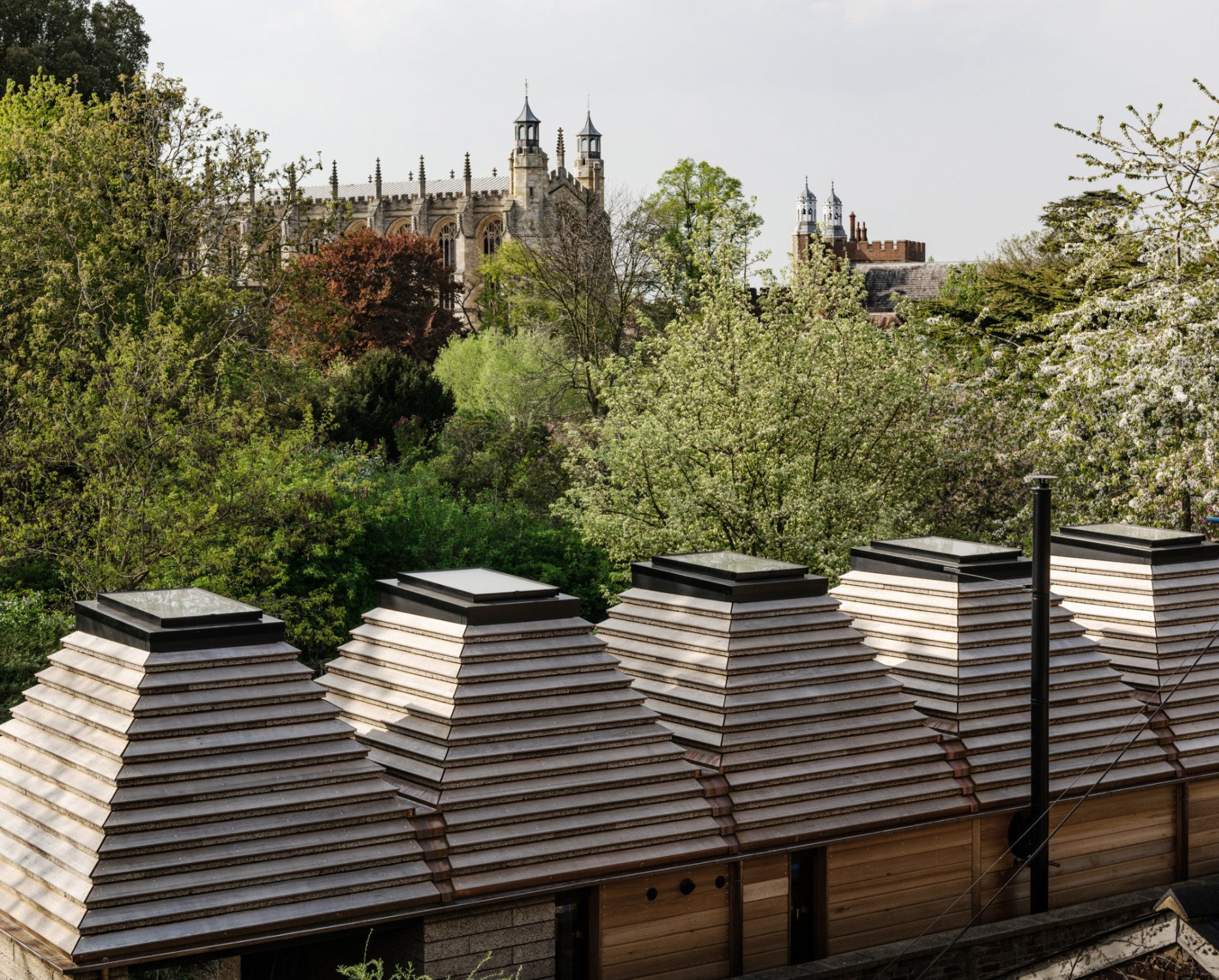 Der Neubau befindet sich auf einer Insel der Themse in Eton, umgeben von Gärten und in unmittelbarer Nachbarschaft einer denkmalgeschützten Mühle aus dem frühen 19. Jahrhundert. Im Hintergrund zu sehen: die Kapelle des Eton College. 