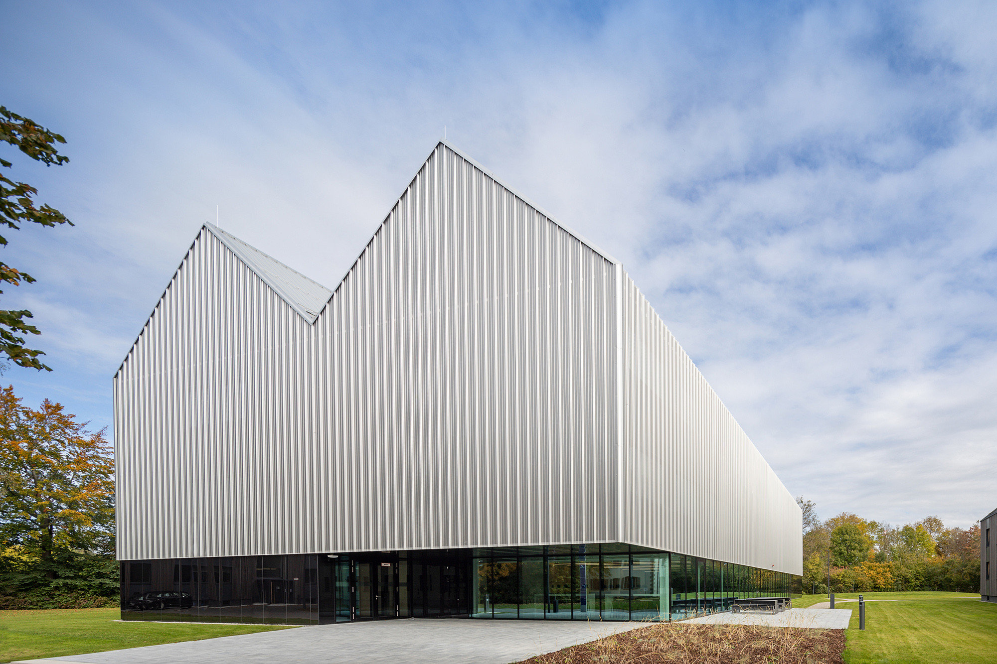 Die Architektur des Schulungsgebäudes wird durch die traditionelle Architektur der Nachbarschaft ebenso bestimmt wie durch eine technische Eleganz, wie sie sonst nur Flugmaschinen auszeichnet.