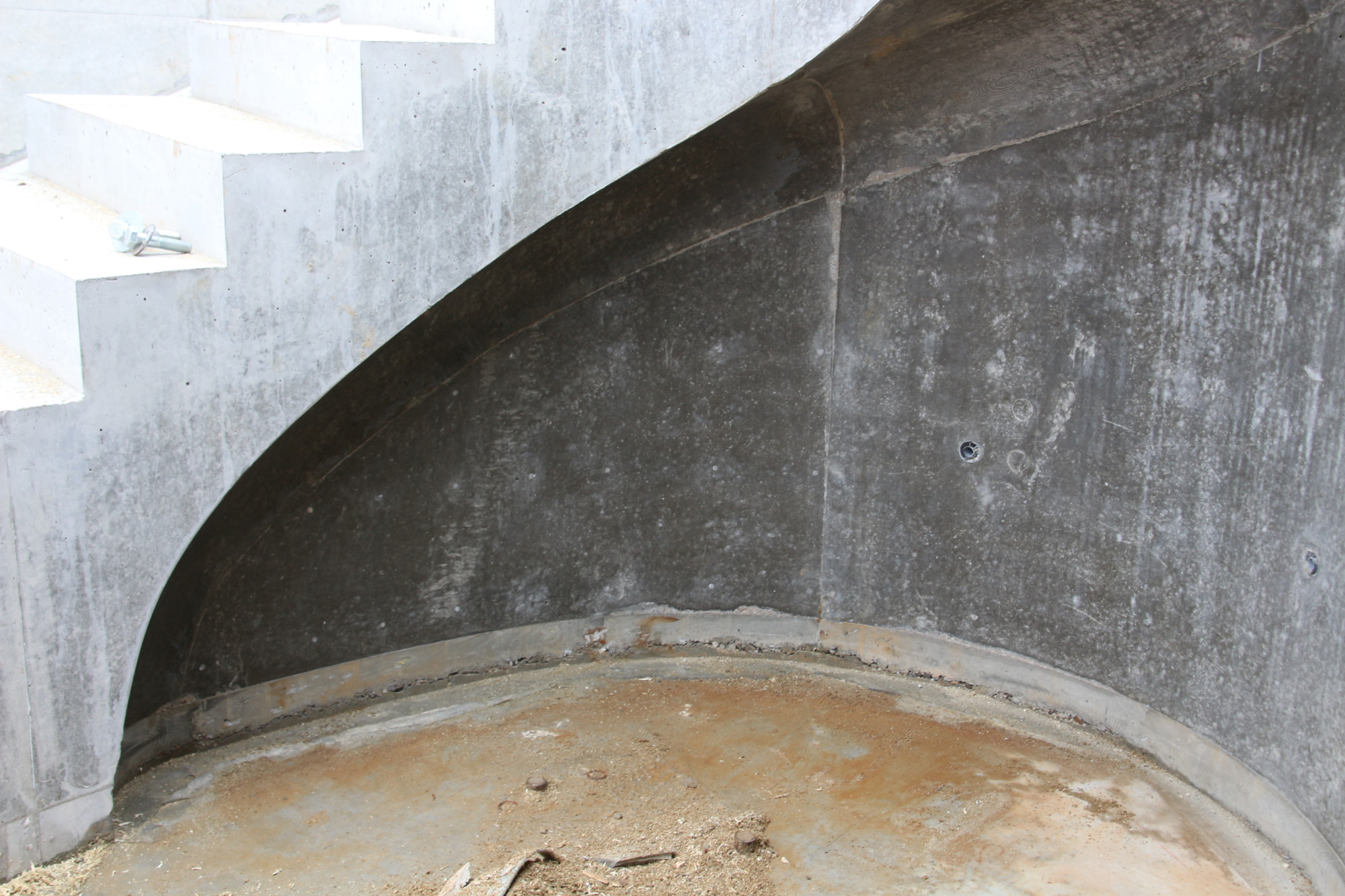 Als Schalhaut waren mehrfach gekrümmte Elemente gefragt, die zum einen die geschwungene Form der Treppe und zum anderen den konkaven Anschluss nachzeichneten.