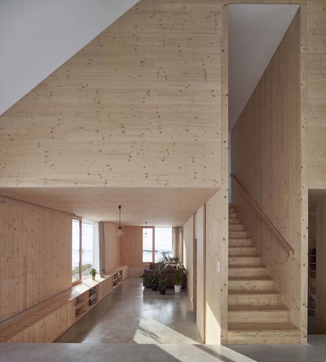 Mit Ausnahme von Wohnküche und Essplatz sind alle Räume des Erdgeschosses in den Betonsockel eingelassen. Das Wohnzimmer hat dadurch Fensterbrüstungen auf Höhe des Gartens