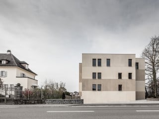 Das von Dolmus Architekten geplante Mehrfamilienhaus befindet sich an der Hauptstraße einer Gemeinde im Seetal bei Luzern und ersetzt ein Einfamilienhaus.