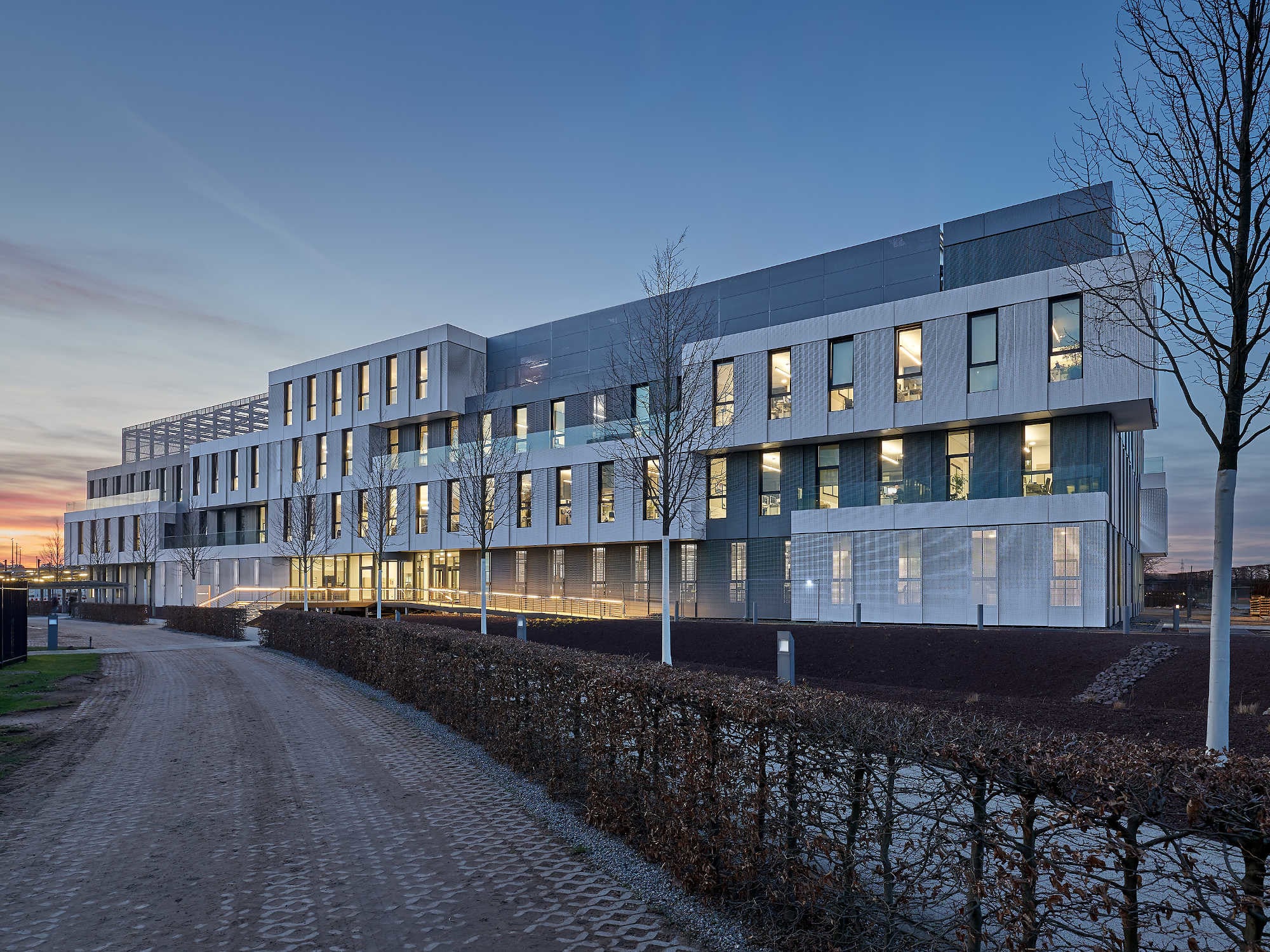 Die der Unternehmenszentrale zugewandte Eingangsseite in der Dämmerung (von Osten)