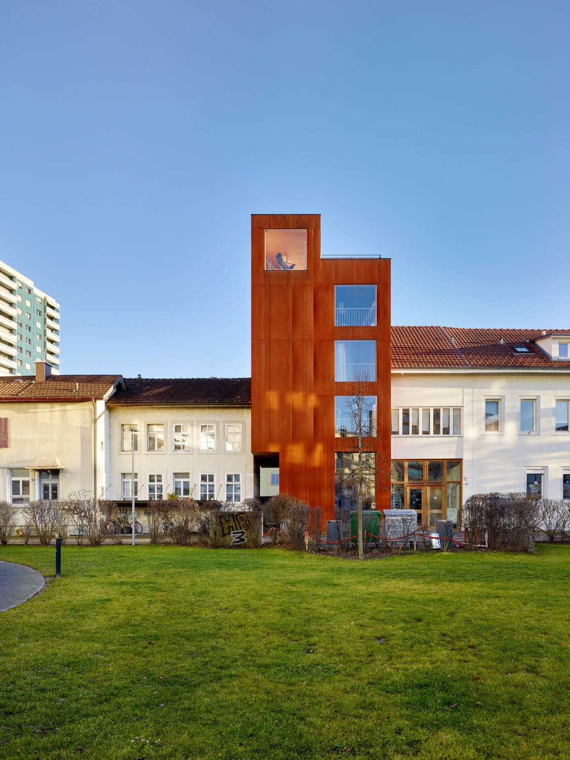 Der Holzelementbau ist mit Cortenstahl-Wellblech verkleidet.