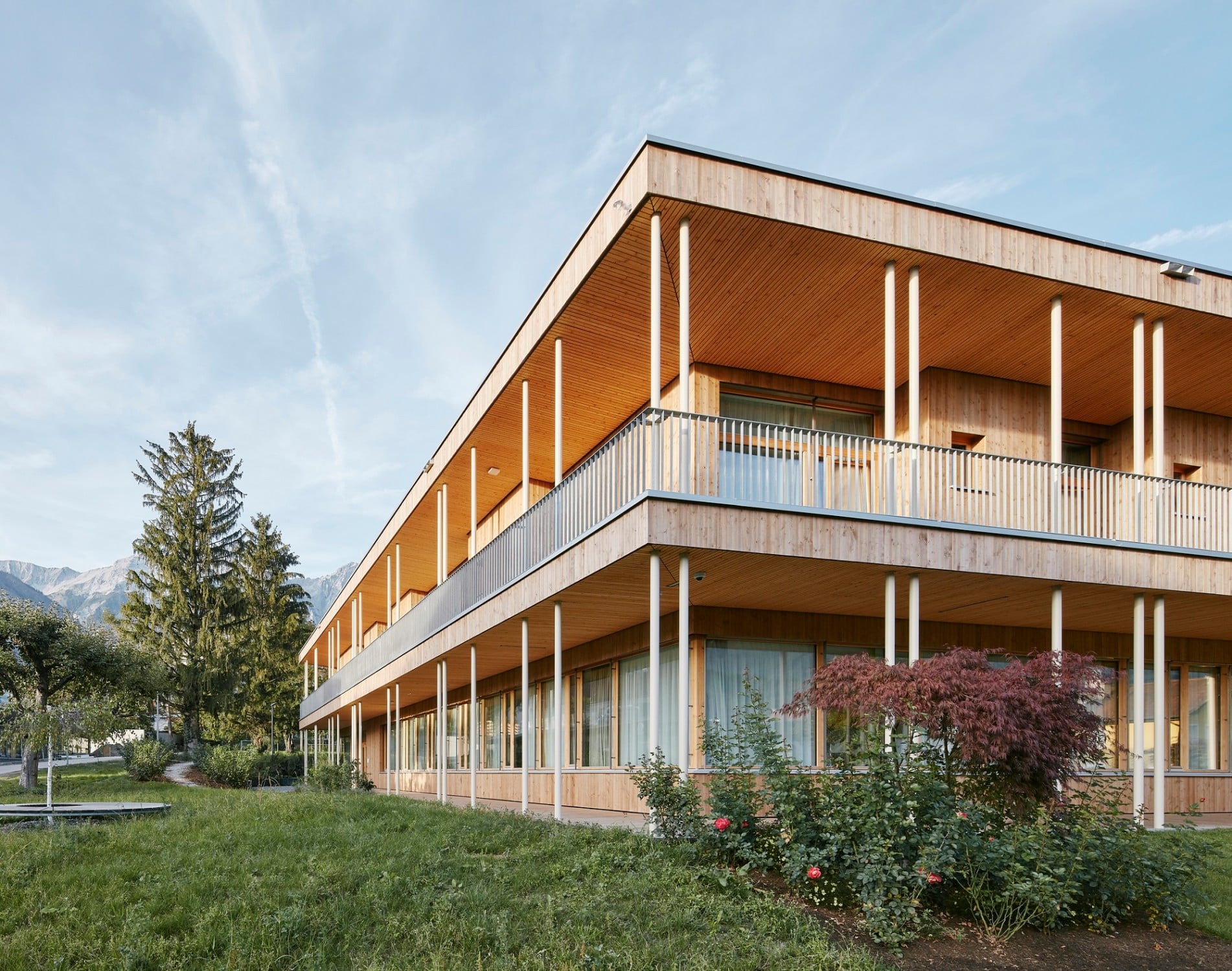Die im Obergeschoss umlaufend tiefen Balkone können mit Krankenbetten direkt befahren werden. Schlanke, weiß lackierte Stahlstützen tragen die Decken.
