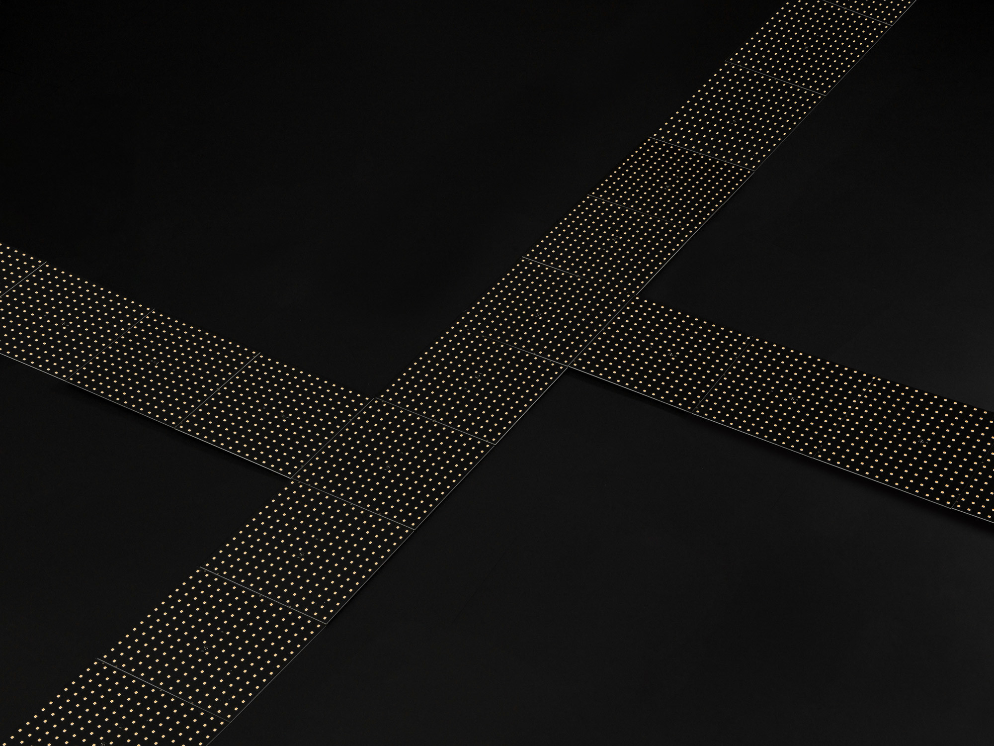 Die gestalterische Idee: ein Schienensystem aus nackten LED-Chips auf Leiterplatten (PCBs), das grafische Lichtskulpturen erzeugt. 