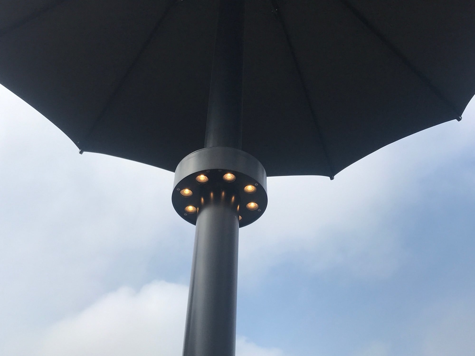 In den Mast der Schirme sind LED-Leuchtmittel integriert.