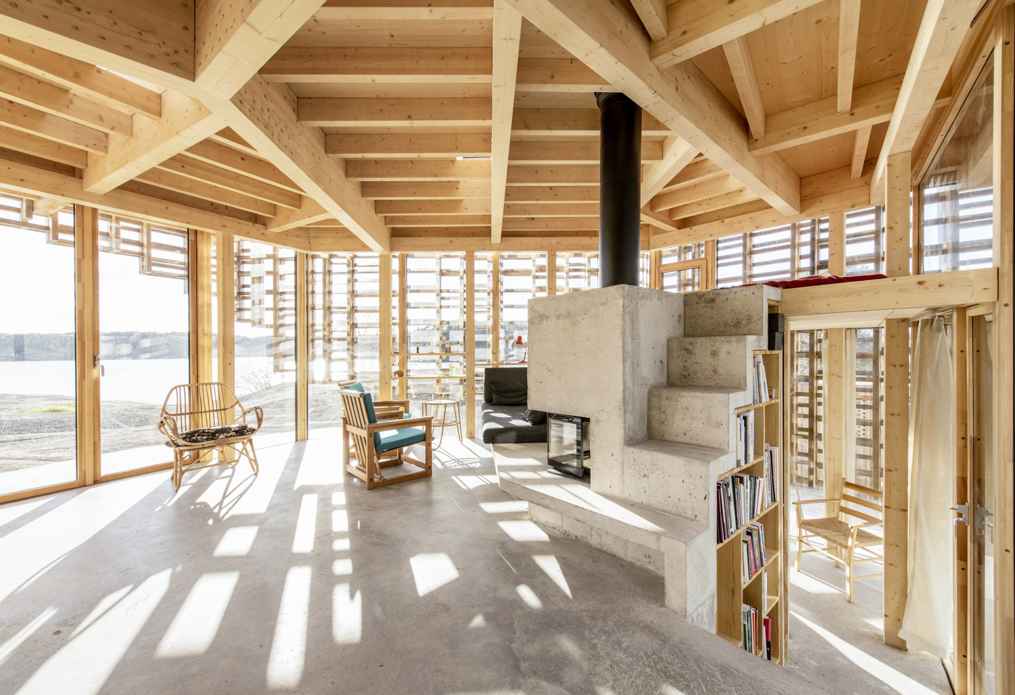 Sichtbeton und Holz im zentralen Wohnraum mit weitem Ausblick zum Meer.