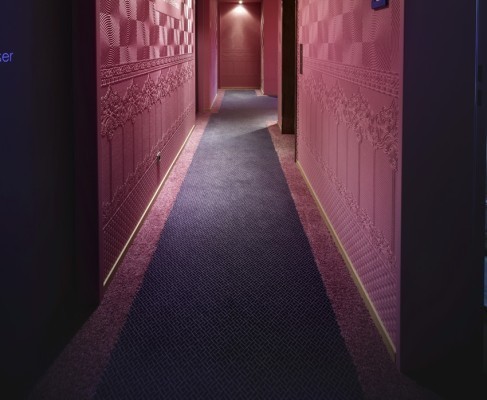 Vierte Etage: Grafisches Flechtmuster in Violett und Blau, gerahmt von leuchtendem Rosa