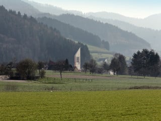 Der rund 33 Meter hohe dreieckige Kirchturm in Holzbauweise ist das Wahrzeichen der Gemeinde.